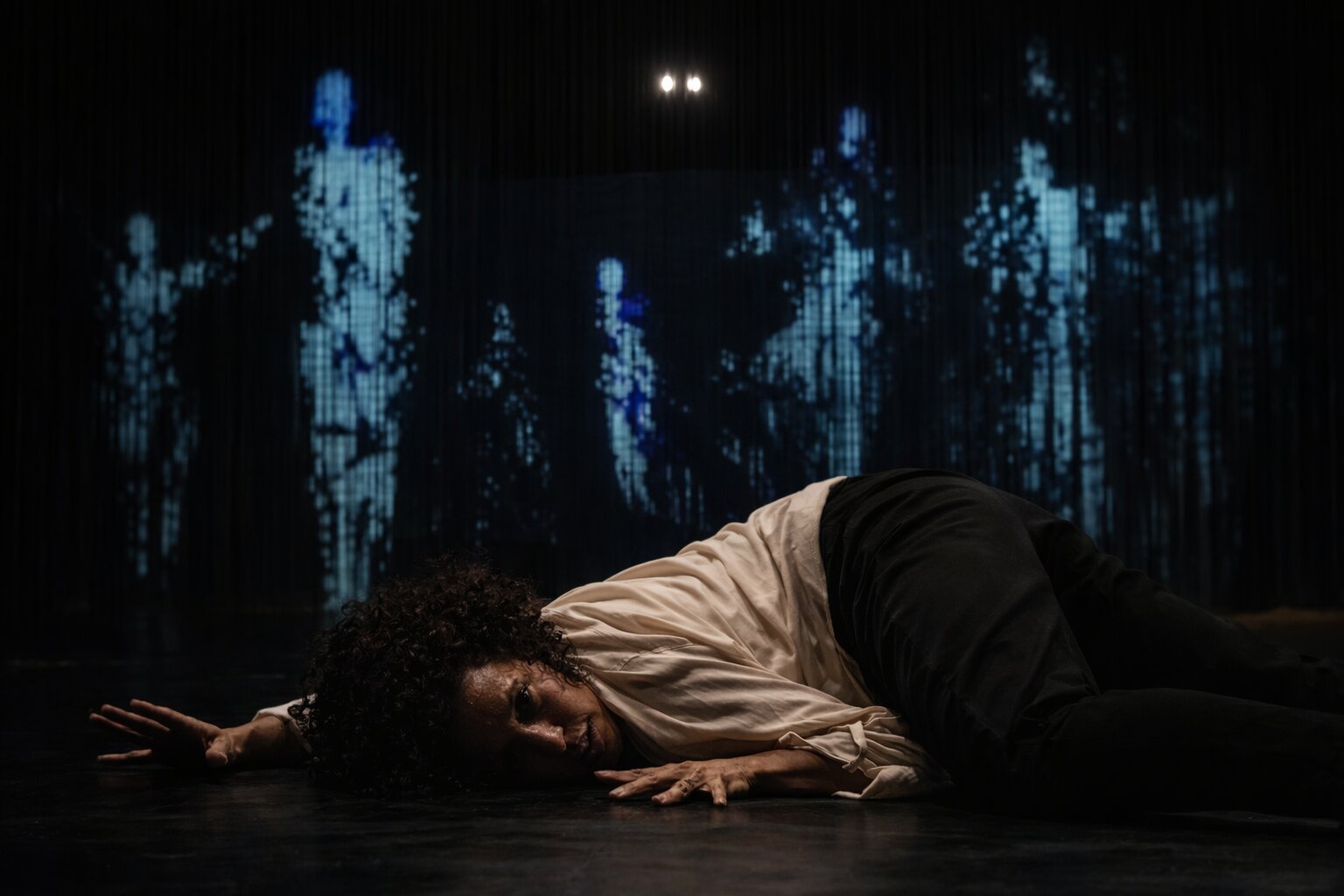 Margaret J Harvey on the floor against a blue-lit backdrop